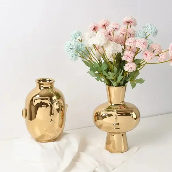 Vase doré en forme de visage abstrait